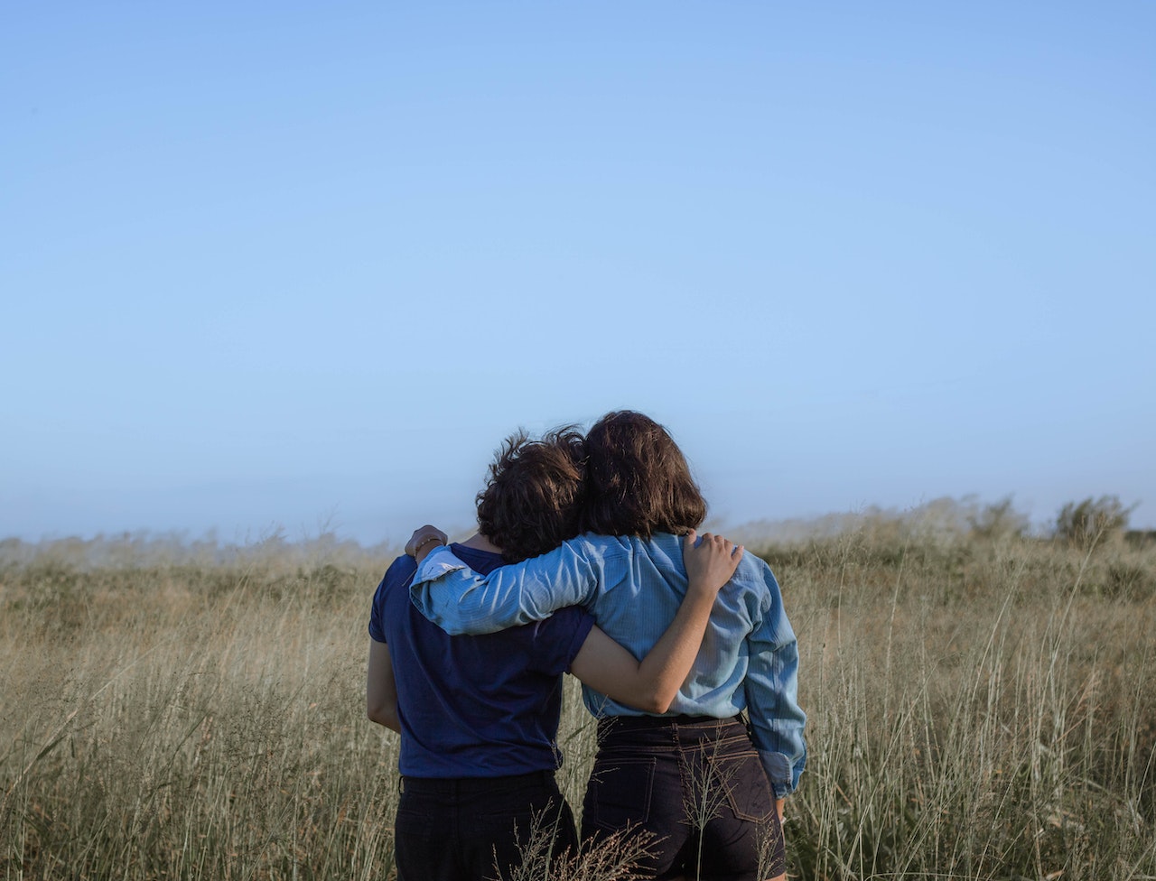 Dos chicas mirando el horizonte abrazándose