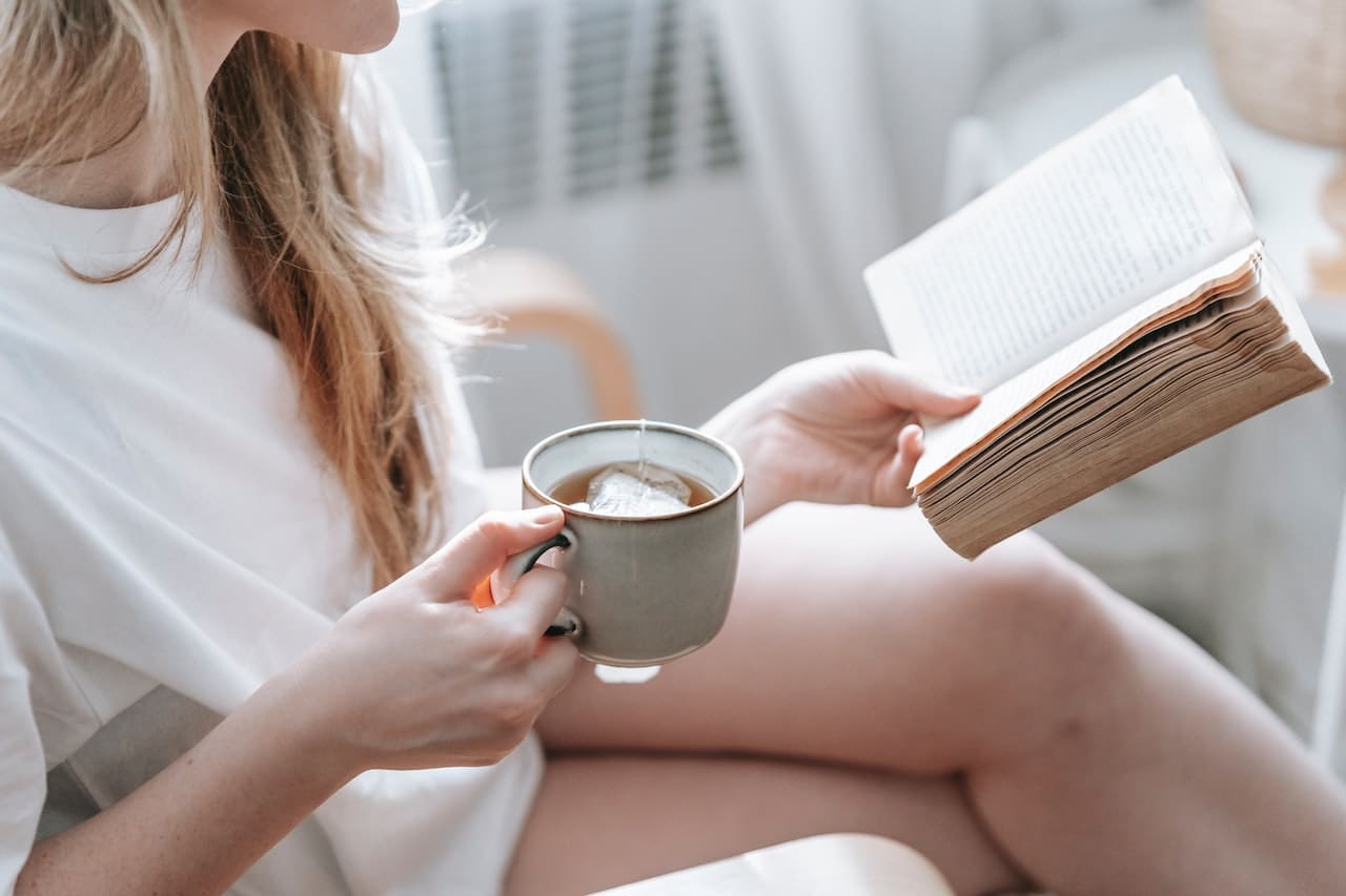 Mujer leyendo con una taza de té