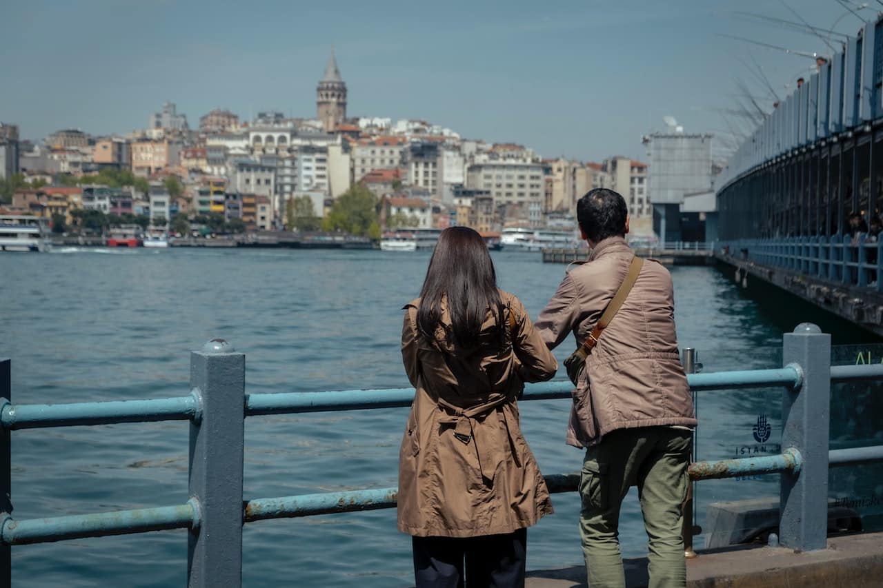 Un hombre y una mujer viendo un río en una barandilla